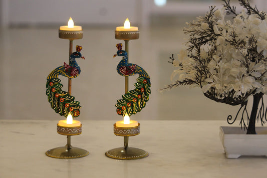 Decorative candle holders with candles on a reflective surface.