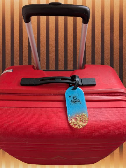 Red suitcase with a blue luggage tag on a striped background