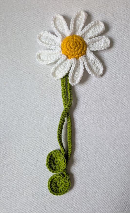 Crocheted daisy flower with green stem curtain tie-up on a light gray background