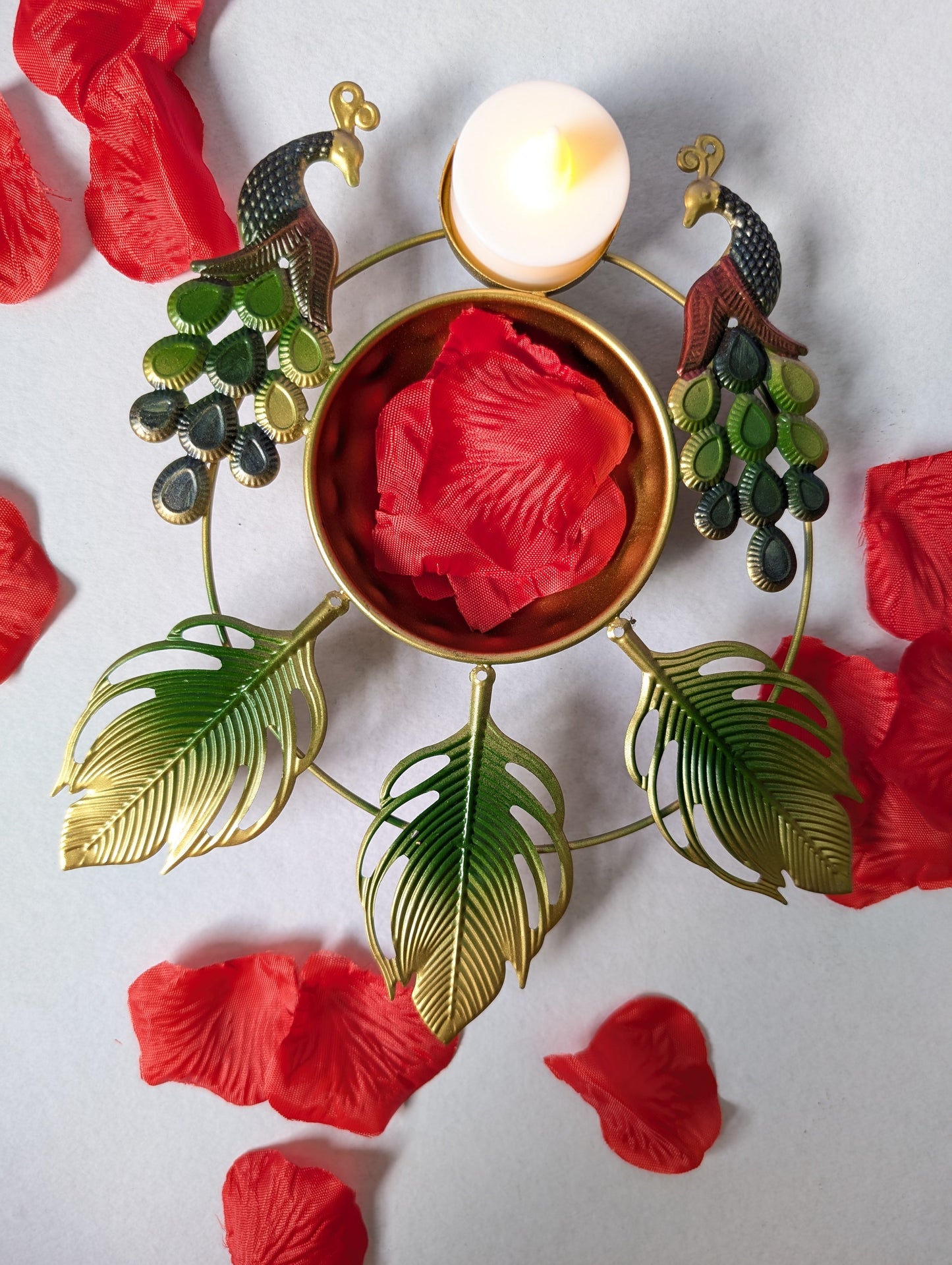 Decorative metal plate with red leaves and a candle on a light background