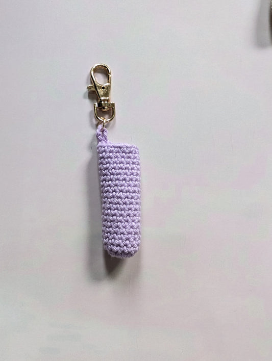 Purple knitted keychain on a white background