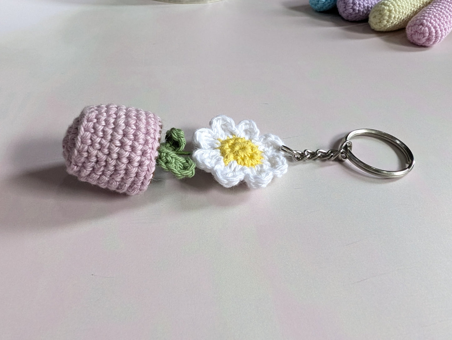 Crocheted keychain with a flower design on a light background