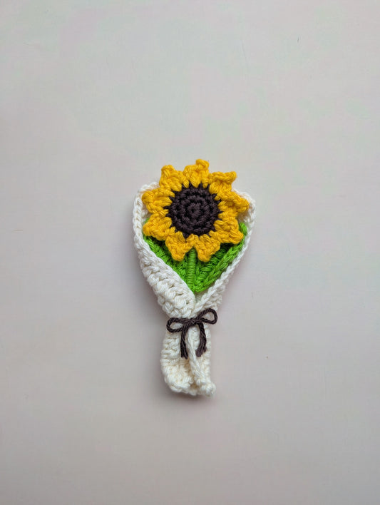 Crocheted sunflower headband on a plain background