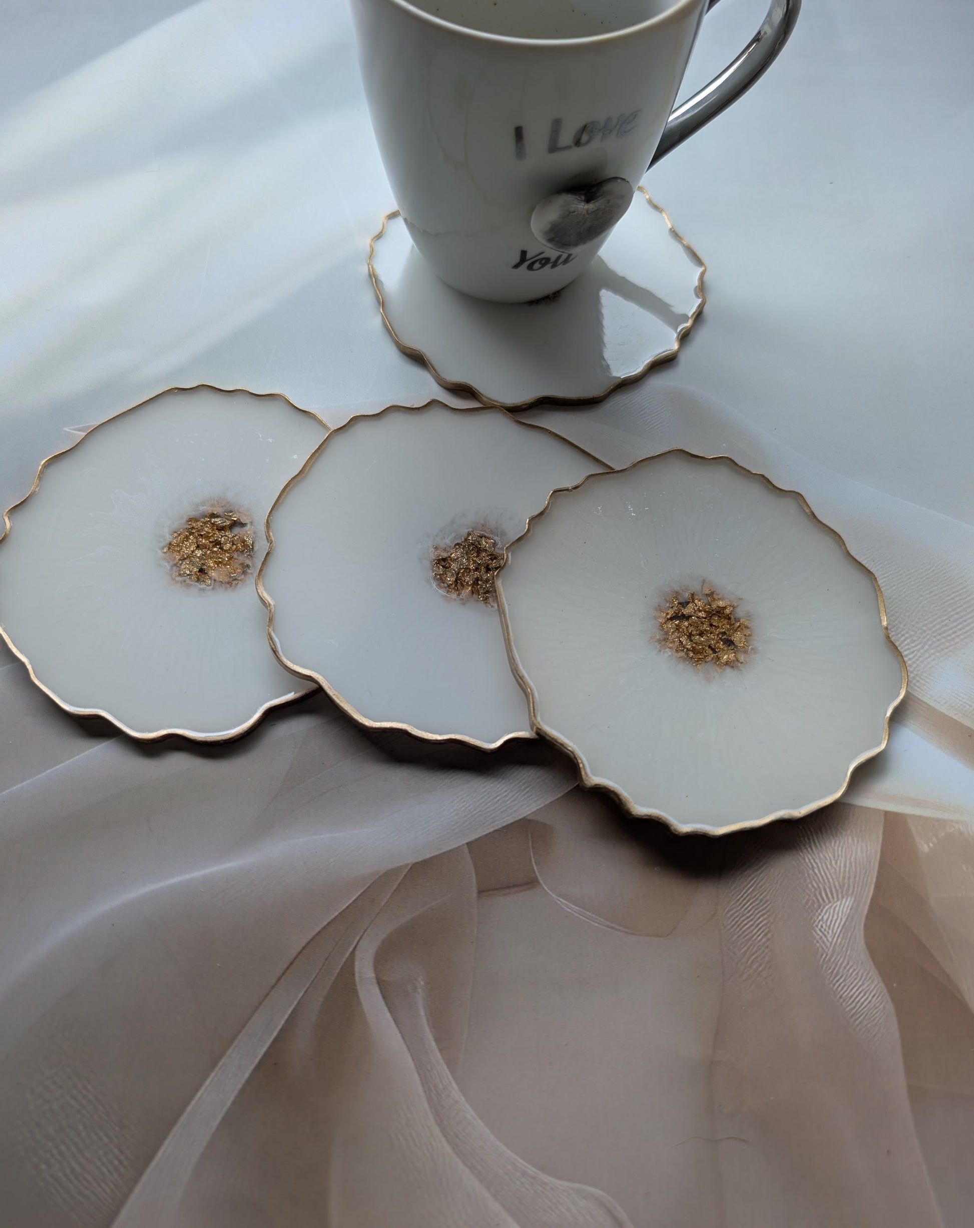 Set of three decorative coasters with a central floral design on a white surface.